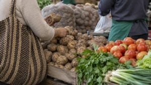 Una mujer escoge papas en un puesto de una plaza de mercado en Colombia.