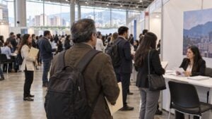 Personas de distintas edades conversan con reclutadores en los stands de una feria de empleo.
