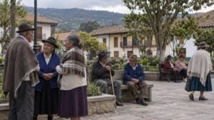 Personas mayores conversan y caminan en la plaza de un pueblo andino de Boyacá.