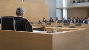 Jueza en toga ante un público en una sala de audiencias de un tribunal internacional.