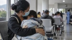 Madre con tapabocas espera con su hijo pequeño en la sala de urgencias pediátricas de un hospital.