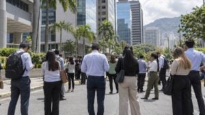 Personas evacuadas esperan en la calle frente a edificios de oficinas tras un temblor.