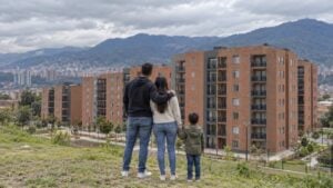 Pareja joven con un niño observa edificios nuevos de ladrillo en el borde de Bogotá.